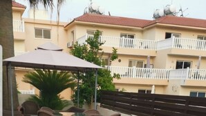 A rooftop terrace with artificial grass, lounge chairs, and wicker furniture. - Nissi Villa Loreana (Ammochostos Ayia Napa)