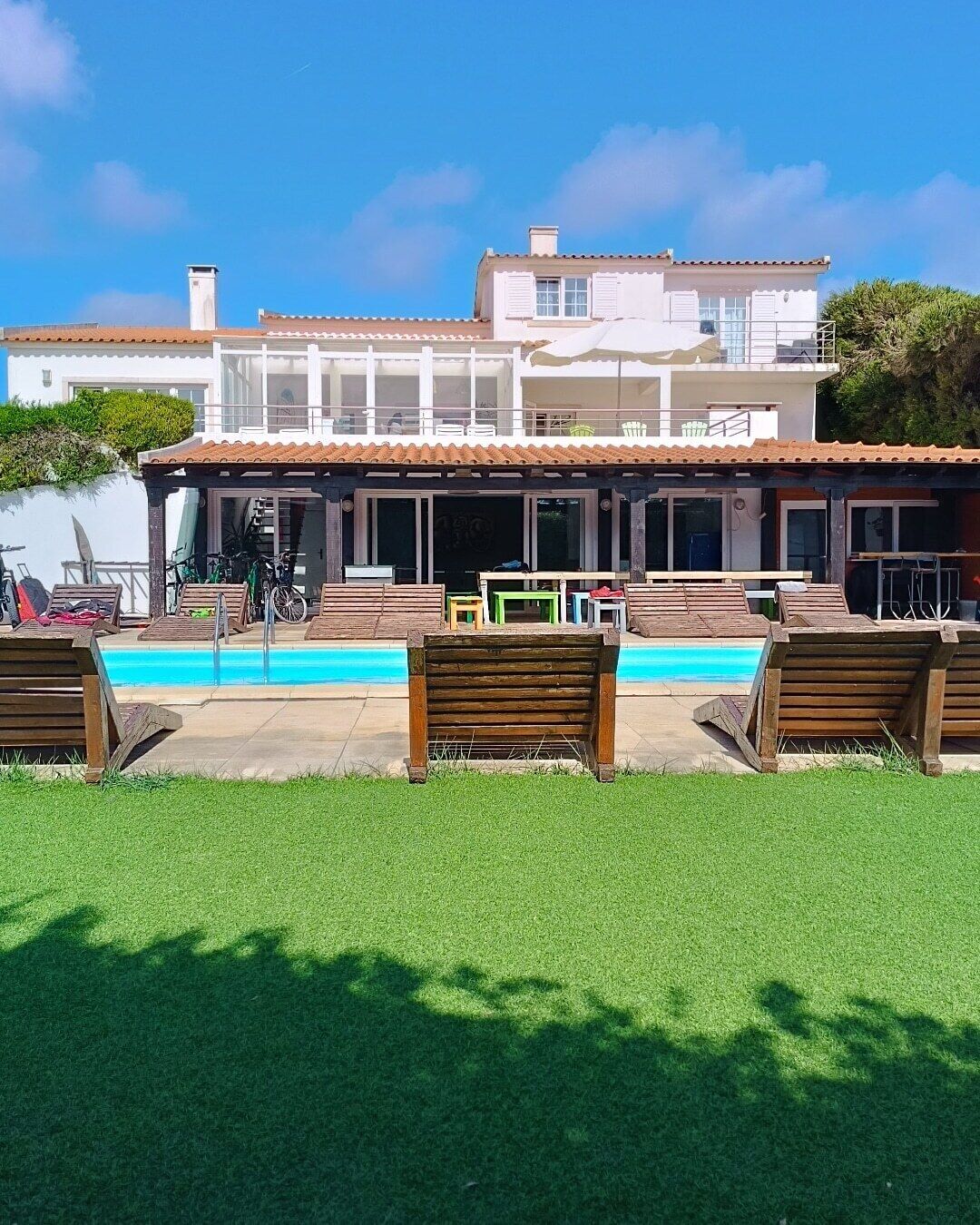 A two-story building with a swimming pool in front.
