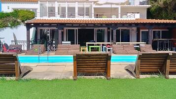 A two-story building with a swimming pool in front.