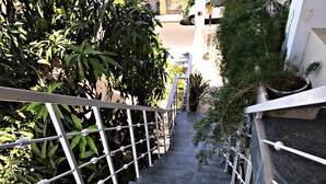 Eine Treppe mit Metallgeländern, umgeben von Grünpflanzen.