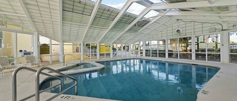 Una piscina interior con techo de vidrio, zona de piscina despejada y un cartel que indica 'No Diving'.