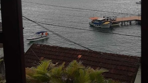 A view of a body of water with a dock and a small boat. - POUSADA PONTA DO ARPAO (Mangaratiba)