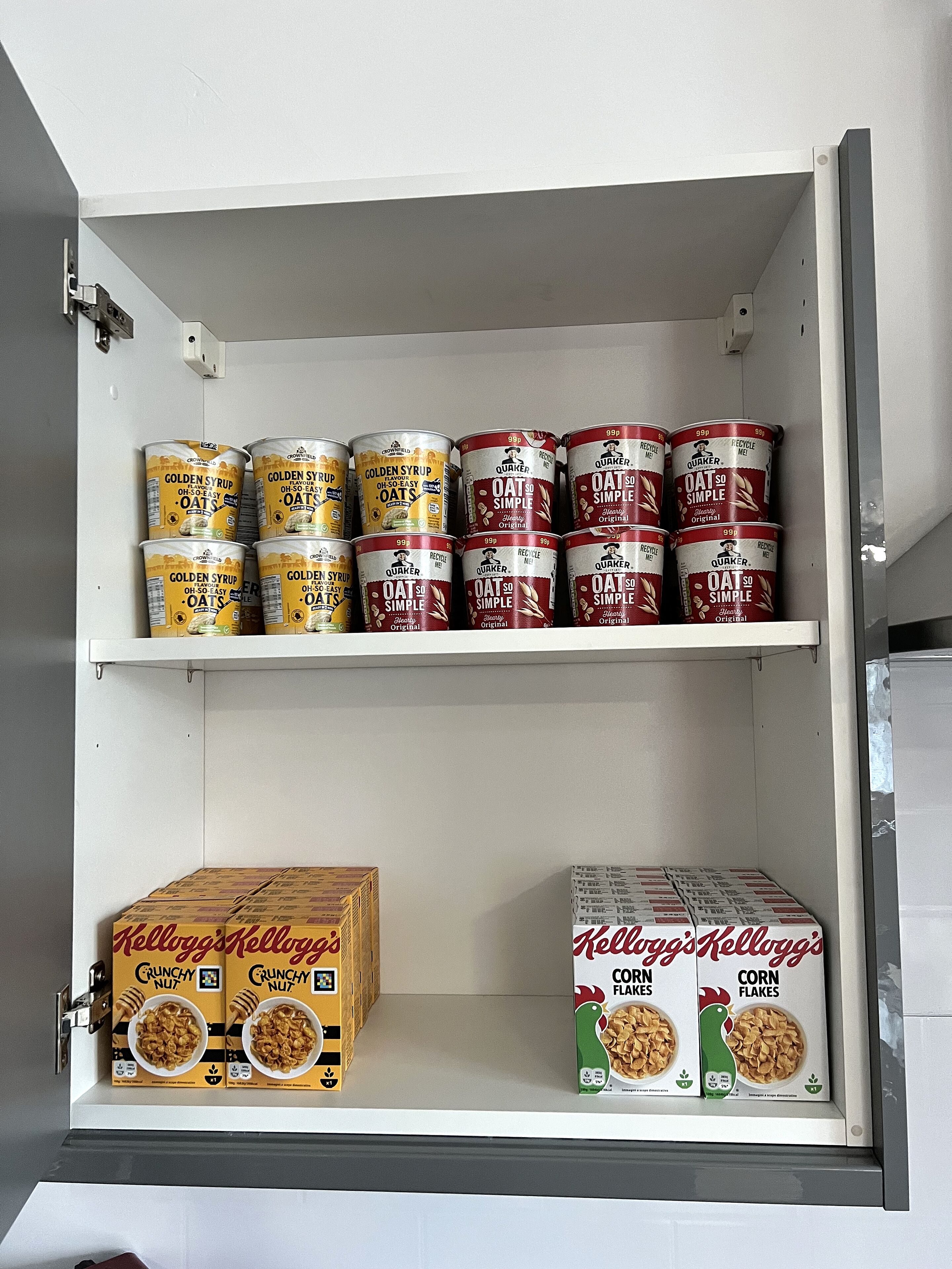 A pantry with shelves stocked with canned goods and cereal boxes.