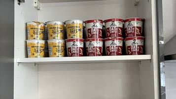 A pantry with shelves stocked with canned goods and cereal boxes.