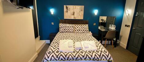 Une chambre d’hôtel avec un lit, un bureau et une chaise.