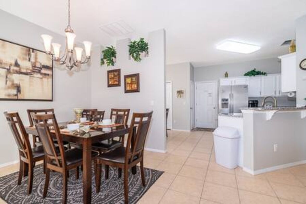 A modern kitchen with white cabinets, a built-in oven, and a small island.