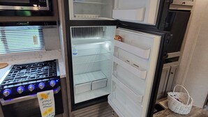 A compact kitchen with a built-in microwave, a gas stove, and a refrigerator. - New little getaway (Fernandina Beach)