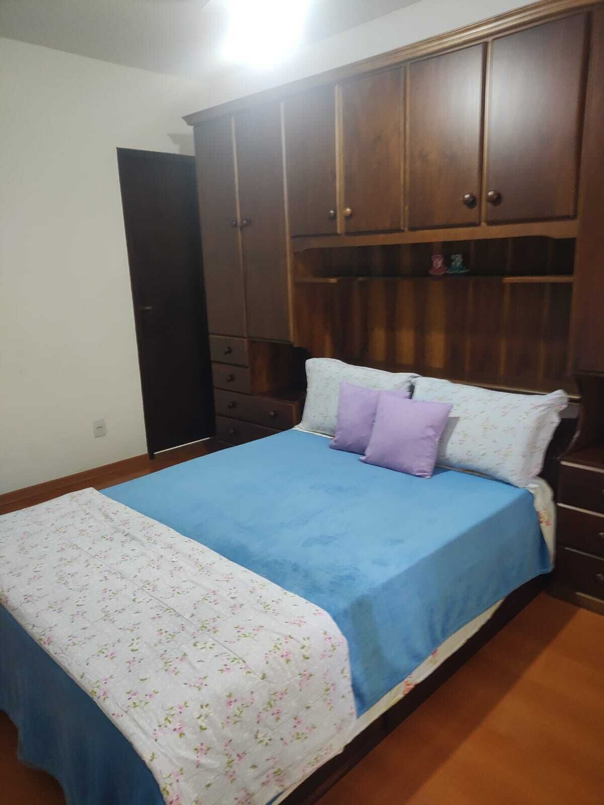 Une chambre à coucher avec un lit, une armoire et une commode.