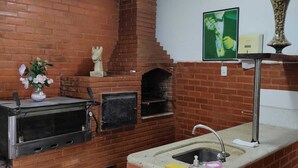 A kitchen with a brick oven, a sink, and a vase with flowers. - Space 579 is the ideal place for you and your family! (Miguel Pereira)