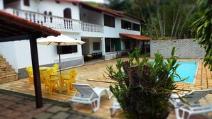 A courtyard with a swimming pool, outdoor seating, and a two-story building with balconies. - Space 579 is the ideal place for you and your family! (Miguel Pereira)
