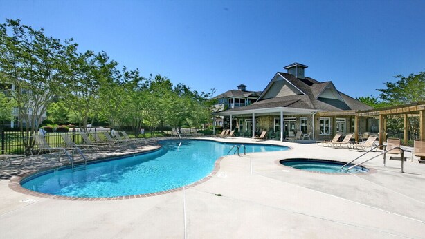 A swimming pool with lounge chairs and a covered patio area. - 280-15 Woodlands Way (Calabash)