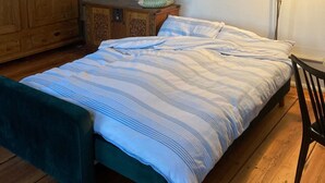 A bedroom with a bed, wooden wardrobe, and a floor lamp. - No letting via FEWO (Lärz)