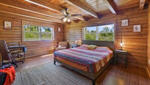 A wooden cabin bedroom with a bed, a desk, and a chair. - Beautiful log cabin w/ private dock, gameroom, 23mi to beach, 3bd2ba, sleeps 11 (Youngstown)