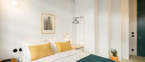 Un dormitorio con cama, mesita de noche, lámpara, aire acondicionado y un cuadro en la pared.