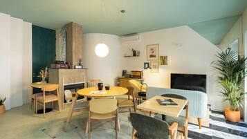 A compact living space with a dining area, a sofa, and a TV.