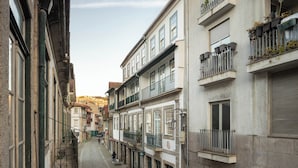 Una estrecha calle adoquinada bordeada por edificios históricos con balcones y ventanas.