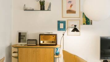 A cozy living room with a wooden cabinet, a vintage radio, and a television.