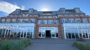 A modern building with a sign reading "APARTHOTEL ANNA DUNE". - Anna Düne 3-44 - Exclusive sea view at Aparthotel Anna Düne (Wangerooge)