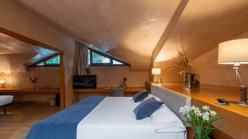 Un dormitorio moderno con una cama grande, un escritorio, una silla y un televisor.