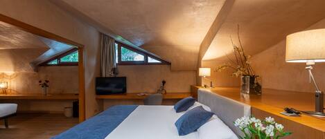 Une chambre moderne avec un grand lit, un bureau, une chaise et un téléviseur.