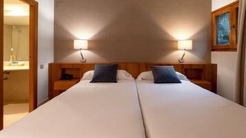 A double bed with two bedside tables, each with a lamp and a phone.