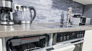 A modern kitchen with Bosch appliances, including a dishwasher and an oven, and a coffee maker on the counter.