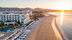 Un resort con piscina, tumbonas y playa.