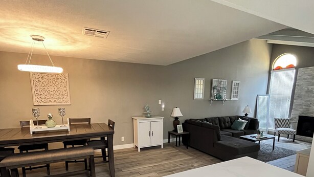 A modern living room with a dining area, a sofa, and a fireplace. - Modern Zen Escape Near Strip, Downtown, Airport & Convention Center (Las Vegas)