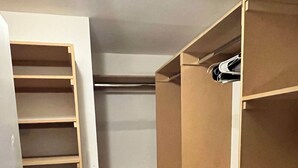 A walk-in closet with open shelving and a built-in closet ladder. - Modern Zen Escape Near Strip, Downtown, Airport & Convention Center (Las Vegas)