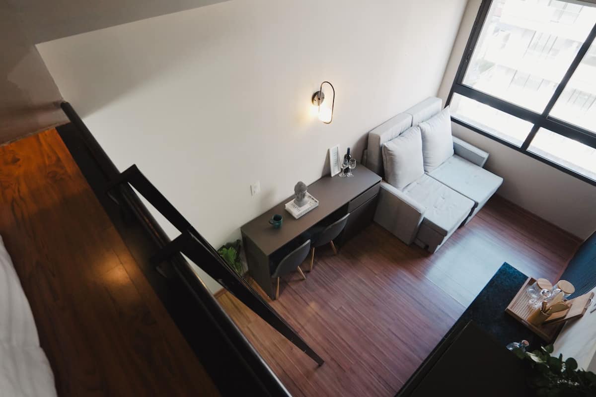 A modern living room with a sofa, a small table, and a desk.