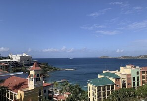 Vista costera con edificios, un puerto deportivo y cielo despejado.
