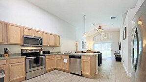 Una cocina moderna con armarios de madera, electrodomésticos de acero inoxidable y una isla grande.
