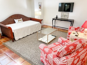 A bedroom with a bed, a glass coffee table, a sofa, a TV, and a side table with a lamp. - Best Apt in Chevy Chase DC Big Sleeps 4-5, 4 blks to Metro (Washington)