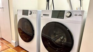 Two front-loading washing machines in a laundry room with tiled flooring. - Best Apt in Chevy Chase DC Big Sleeps 4-5, 4 blks to Metro (Washington)