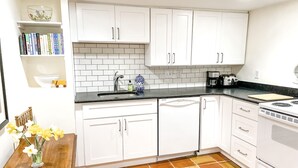 A kitchen with white cabinets, a black countertop, and a tiled floor. - Best Apt in Chevy Chase DC Big Sleeps 4-5, 4 blks to Metro (Washington)