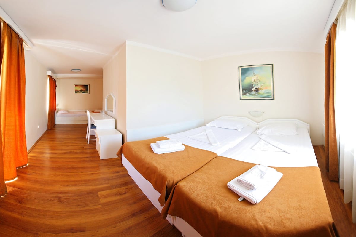 Habitación de hotel con dos camas, un escritorio y una silla.