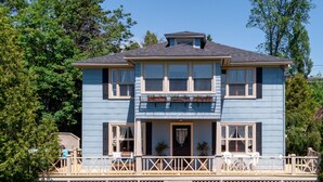 A two-story house with a balcony and a small porch area. - Ancestral home, Charlevoix - Saint-Irénée Beach & St. Lawrence River view (Saint-Irénée)