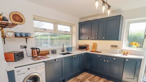 A modern kitchen with a washing machine, a toaster, a kettle, and a microwave. - Robellen Corner (Banbury)