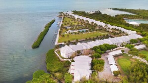 Vue aérienne d’un complexe hôtelier comprenant plusieurs bâtiments, un quai et une voie navigable.