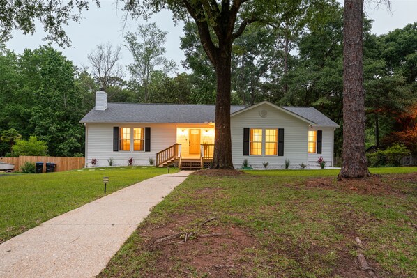 A single-story house with a front porch, a visible staircase, and a well-maintained lawn. - Hamilton Hideaway- Pool, Creek View w/ Scenic Deck (Mobile)