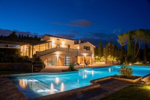 A large house with a swimming pool, a covered patio, and a well-lit exterior at night. - Le Cappuccinelle Suites&SPA (Perugia)