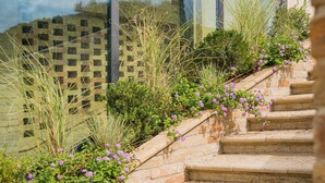 A stone staircase leading up to a modern building with large glass windows. - Le Cappuccinelle Suites&SPA (Perugia)