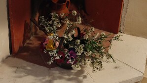 A fireplace with a white mantel, a red brick wall, and a vase with flowers. - Casedda Ostunese (Ostuni)
