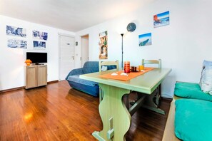 A cozy living room with a dining table, a sofa, and a TV. - HAVANA - Apartment with Sea View (Rovinj)