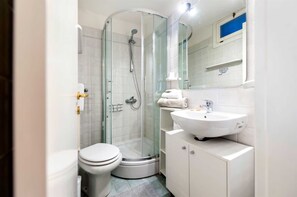 A modern bathroom with a glass-enclosed shower, a white toilet, and a sink with a mirror above it. - HAVANA - Apartment with Sea View (Rovinj)