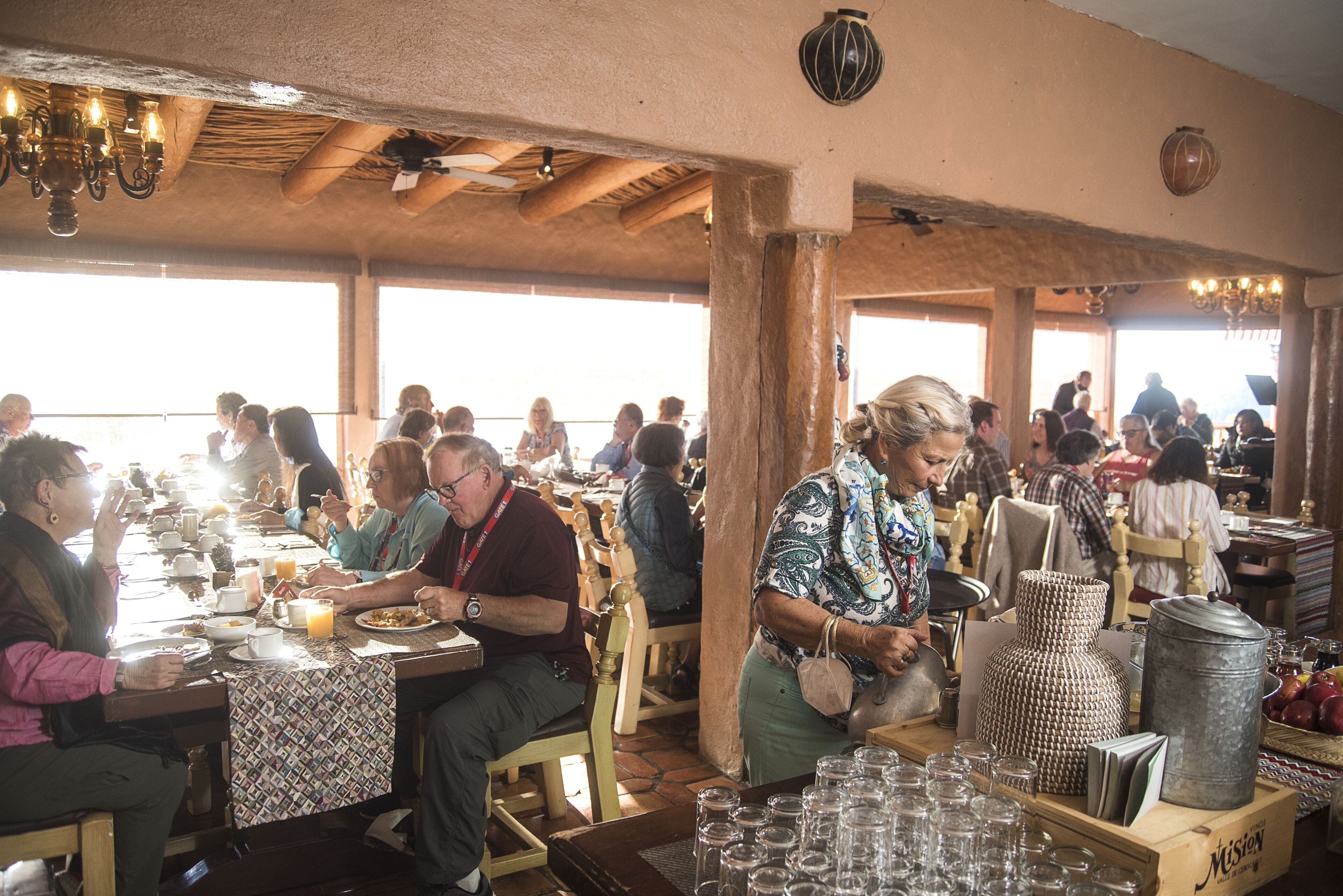 A restaurant with wooden tables and chairs, serving food and drinks.