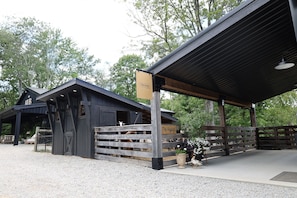 A barn with a covered entrance and a sign reading 'The Barn.' - Parker's Point by Creative Cabins (Logan)