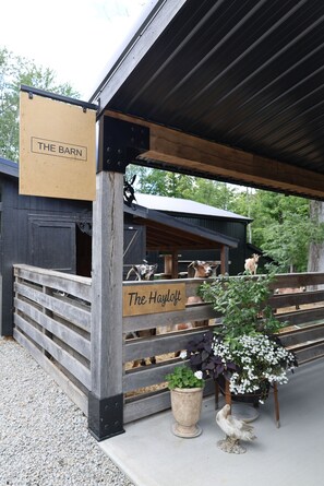 Un bâtiment de style rustique, rappelant une grange, avec une façade en bois et une enseigne indiquant « The Barn ».