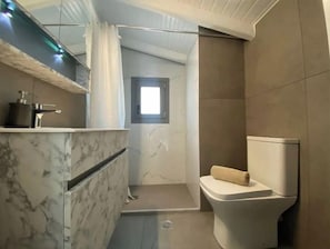 Bañera, secador de pelo, toallas, shampoo