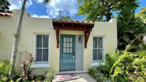 A house with a green door, two windows with shutters, and a tiled porch. - TOP FLORIDA's La Casita (Fort Myers)